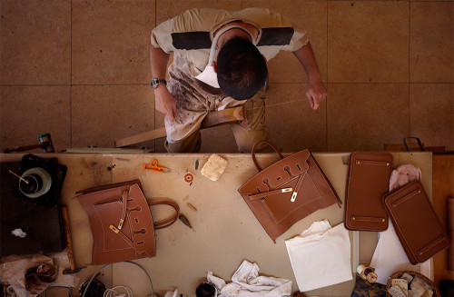 A craftsman piecing together a leather handbag | Source: Courtesy Hermès